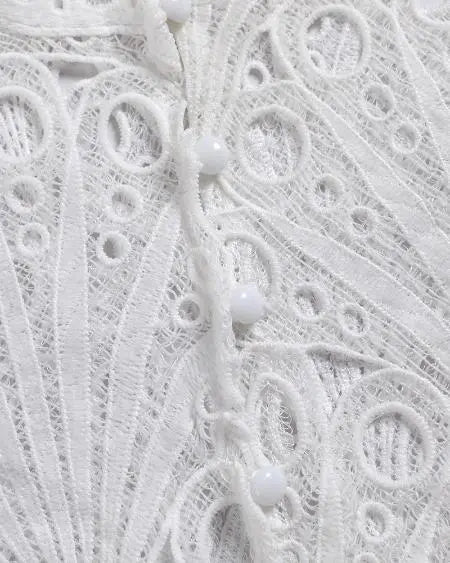 Top met knoopsluiting, geborduurde oogjes en wijde mouwen 